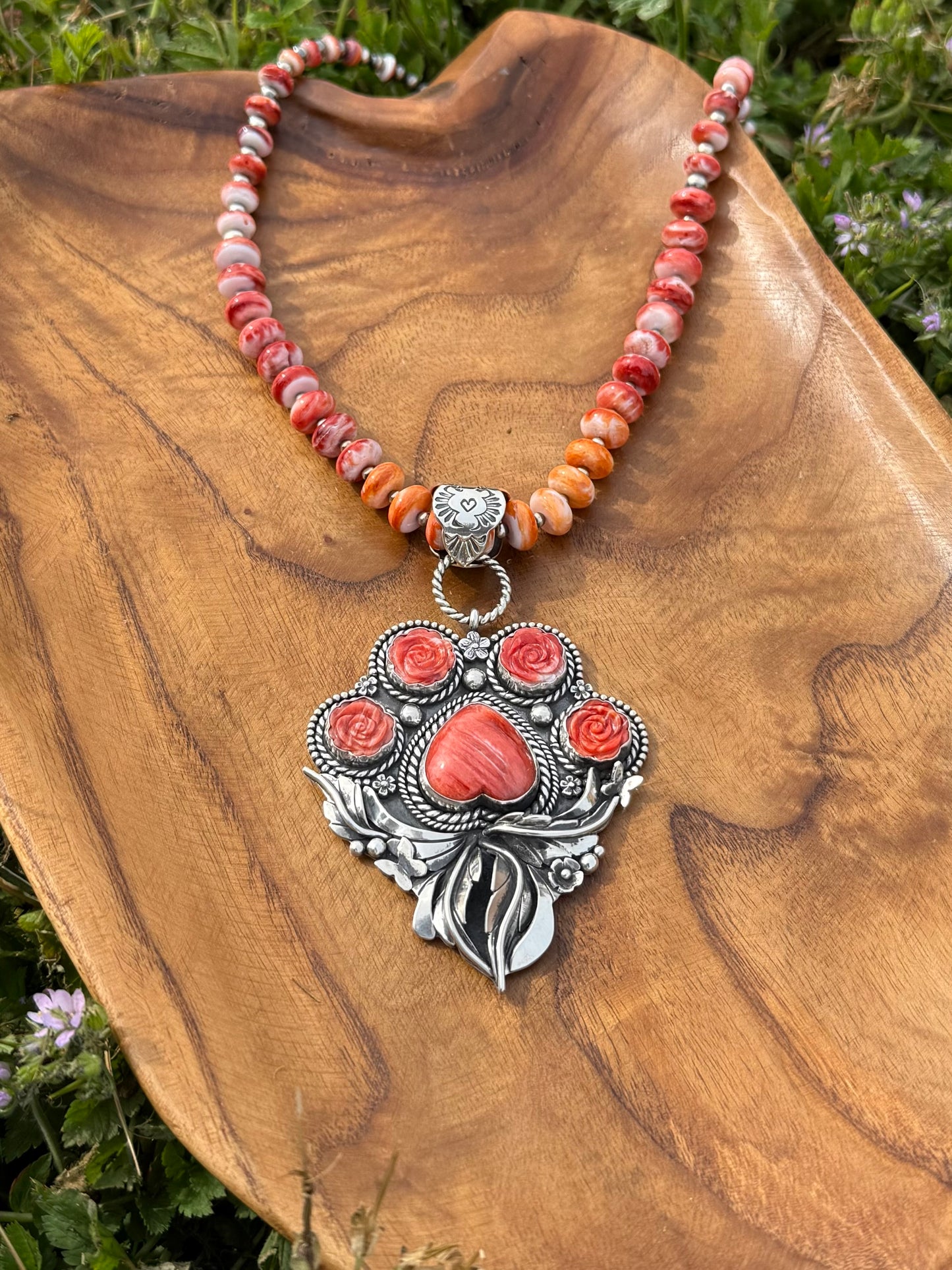 Side view of large sterling silver paw pendant with red spiny oyster stones, handmade statement piece