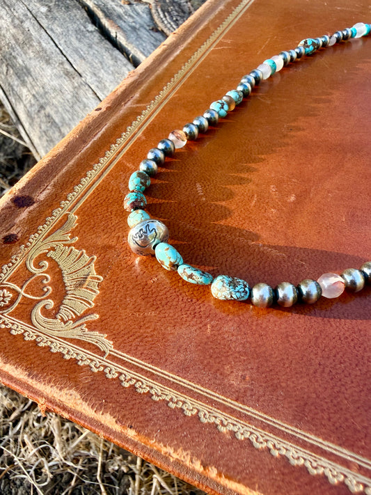Handmade sterling silver bead stamped with bear pine trees and antlers surrounded by Mine 8 turquoise