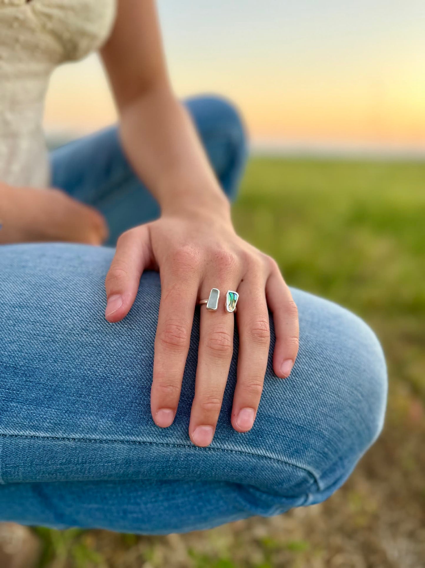 Person wearing two rings on a grassy field