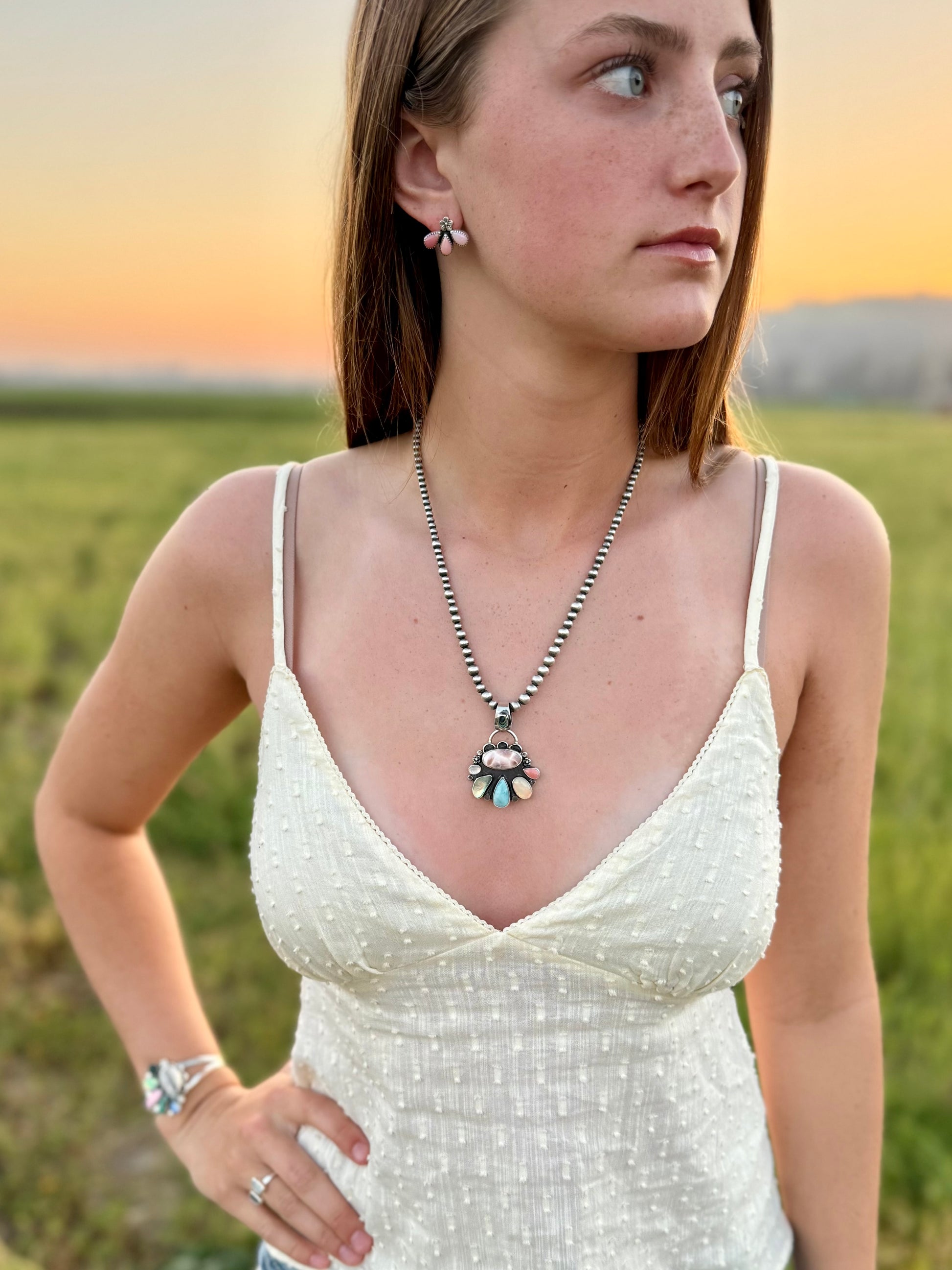 Pink conch stud earrings in sterling silver with soft blush pink stones shown with matching necklace