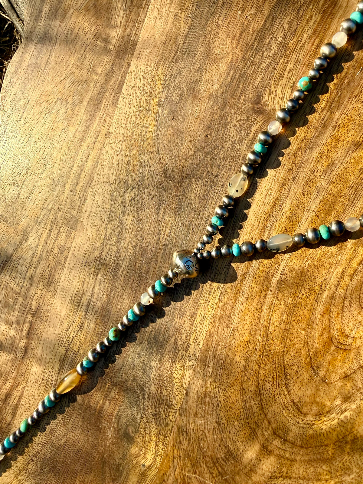 Hand stamped sterling silver focal bead with bear pine trees Ear Mountain and antlers on Montana lariat necklace