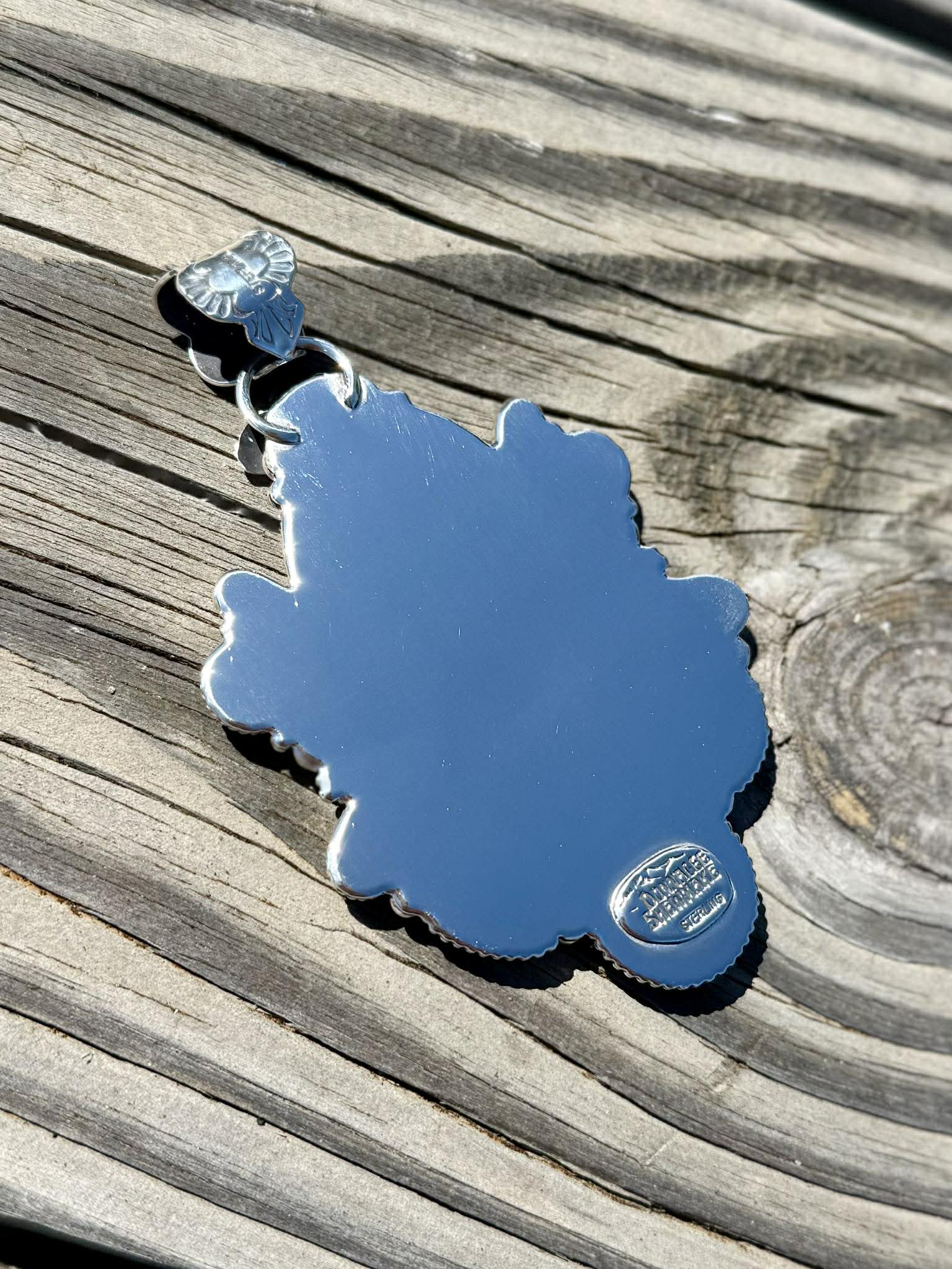 Back of sterling silver pendant showing handcrafted detail and bale