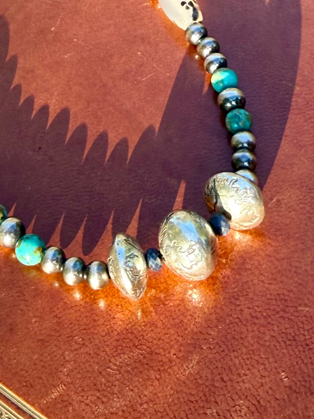 Handmade sterling silver beads stamped with bear eagle moose Ear Mountain pine trees and antlers on Montana Collection necklace