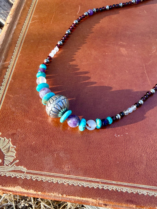 Close up of Montana Agate Amethyst Kingman turquoise Garnet and decorative sterling silver beads