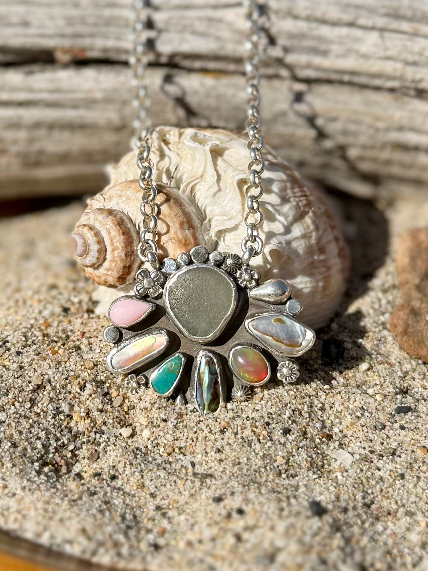 Necklace with sea glass and ethiopian opal and shell featuring colorful stones on a sandy background