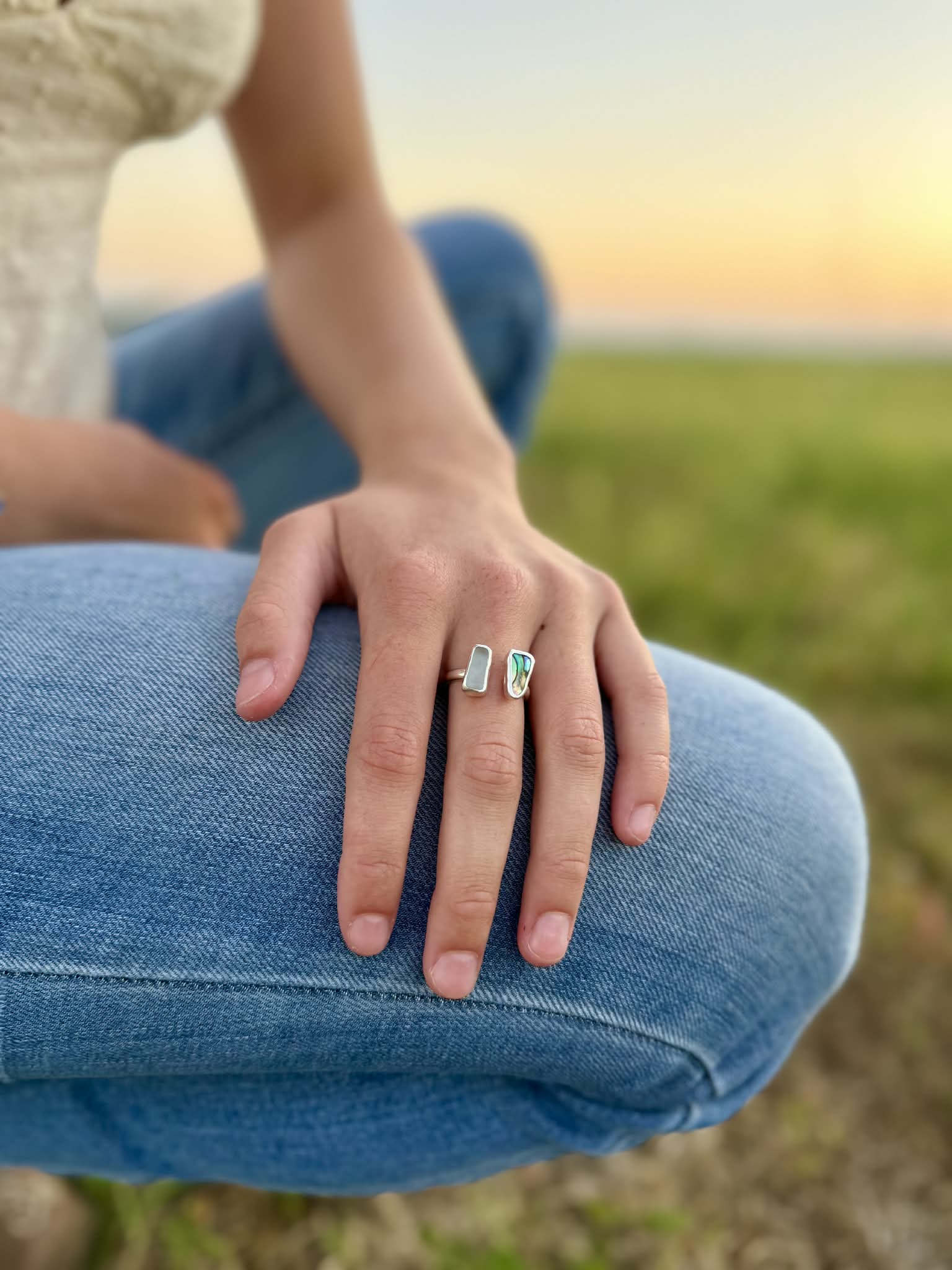 Person wearing two rings on a grassy field