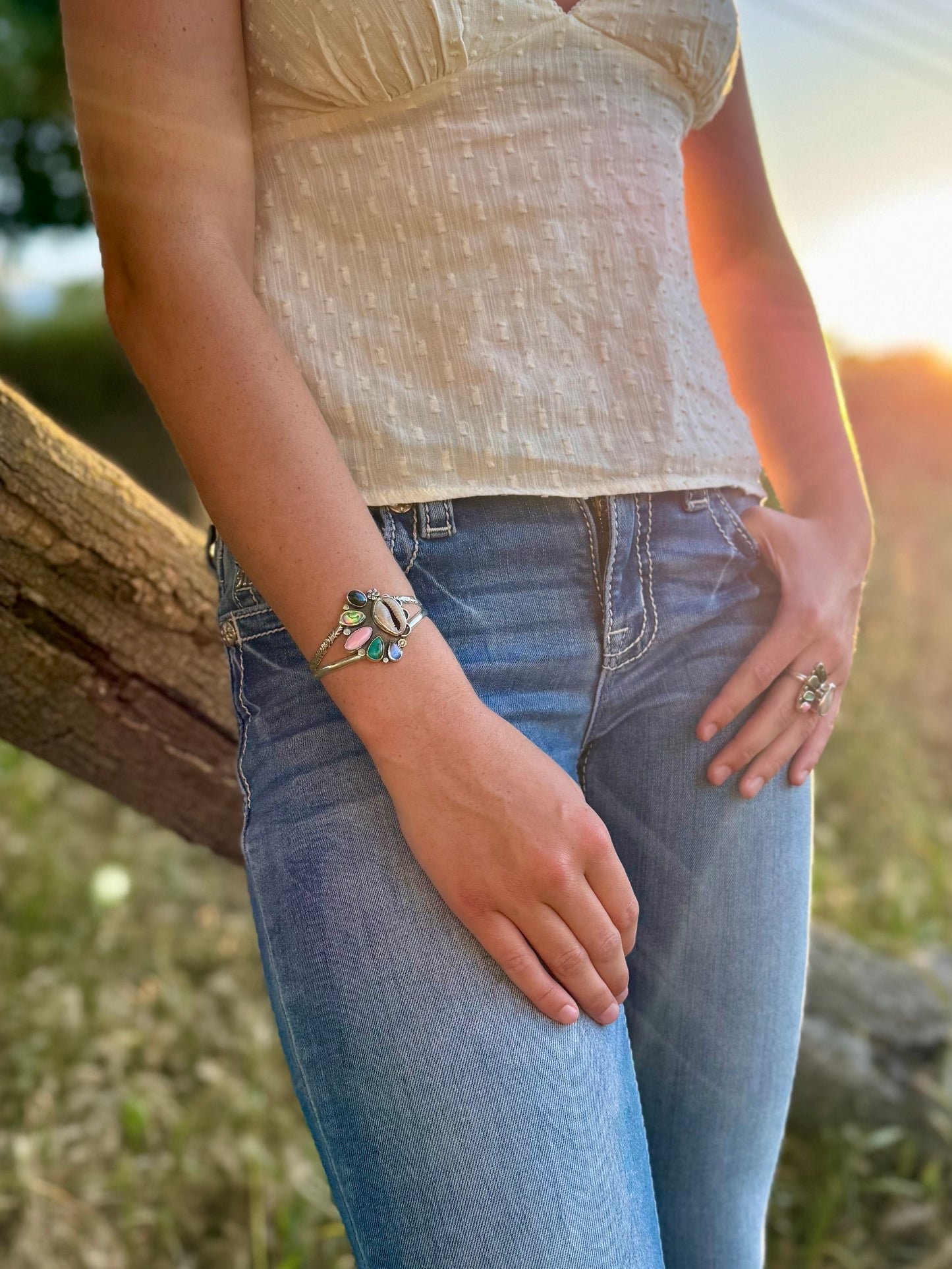 Person wearing a bracelet and ring with a natural background