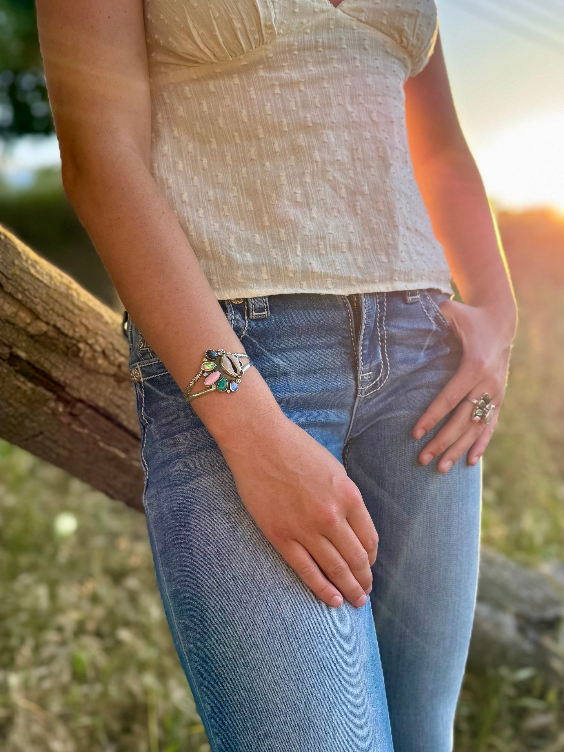 Person wearing a bracelet and ring with a natural background