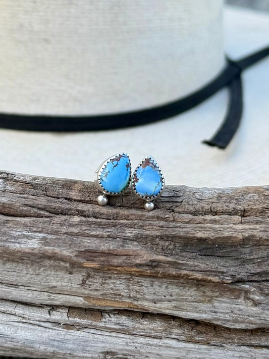 Close-up of Golden Hills turquoise teardrop studs showing light blue color and natural matrix