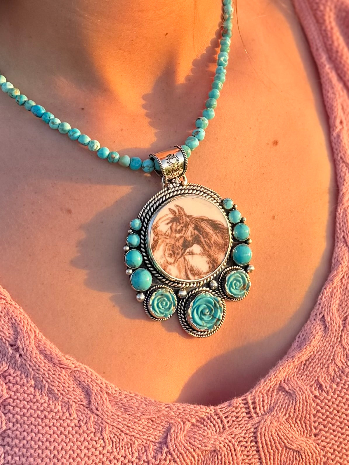 Necklace with a pendant featuring a horse design, and turuoise carved roses