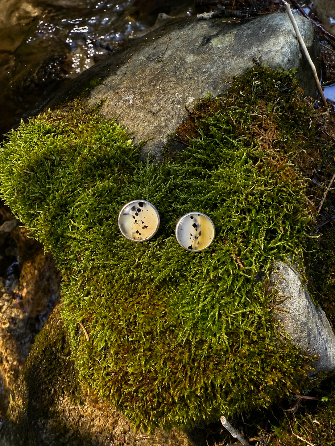 Handmade round Montana Agate sterling silver stud earrings featuring natural translucent coloring and distinctive dark inclusions.