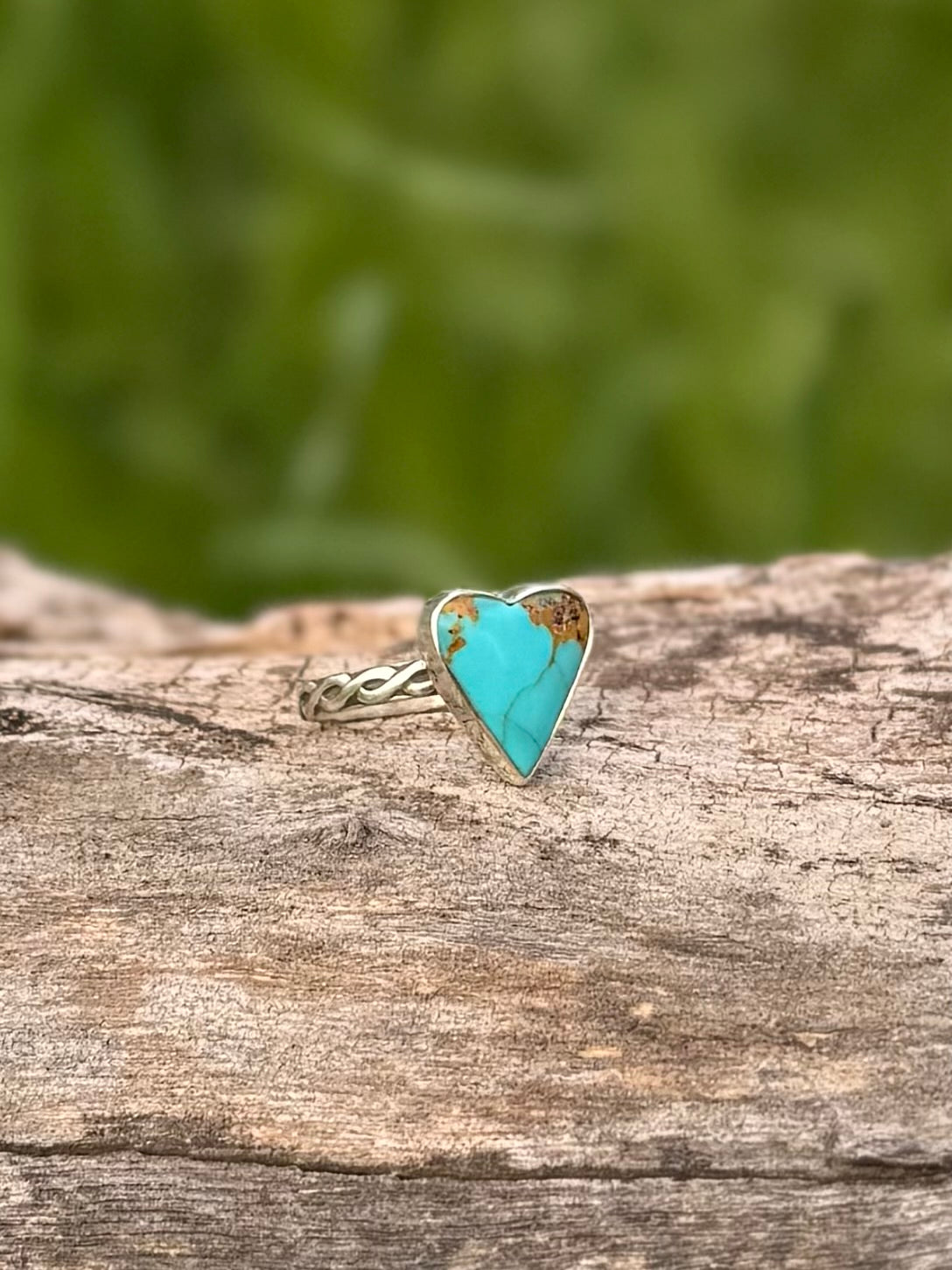 Side view of sterling silver heart ring showing turquoise setting and band
