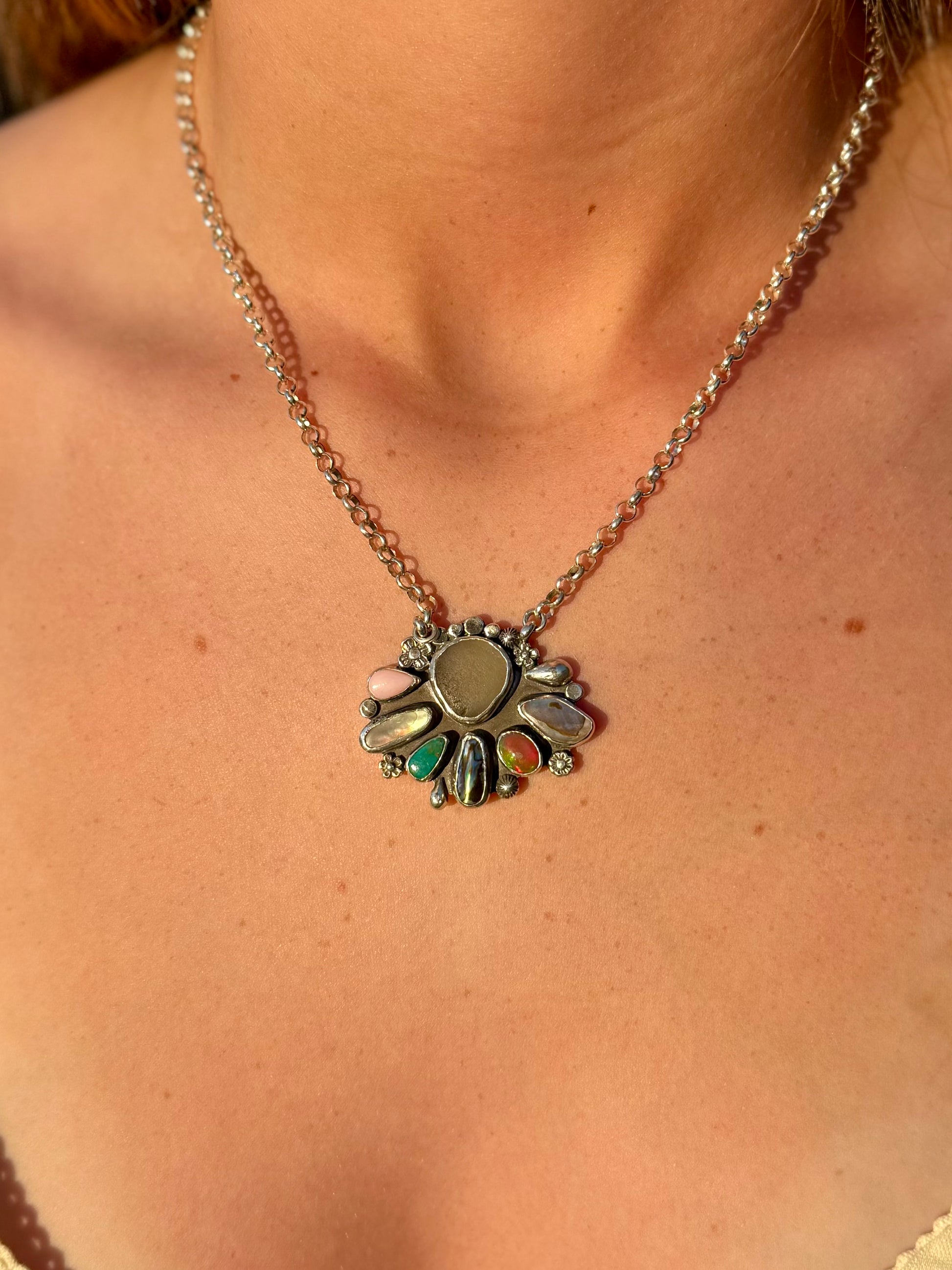 Necklace with a colorful pendant worn by a woman showing the iridescent and rainbow colors in the stones