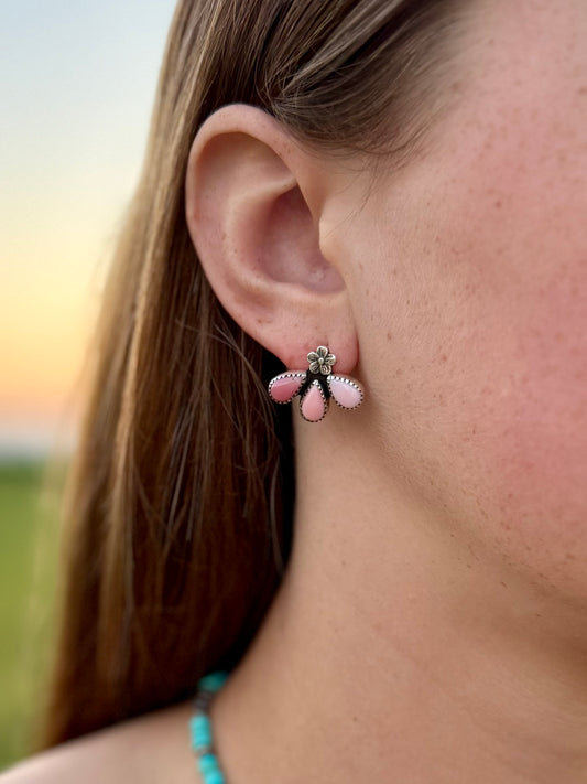 Pink conch stud earrings showing size and proportions on ear