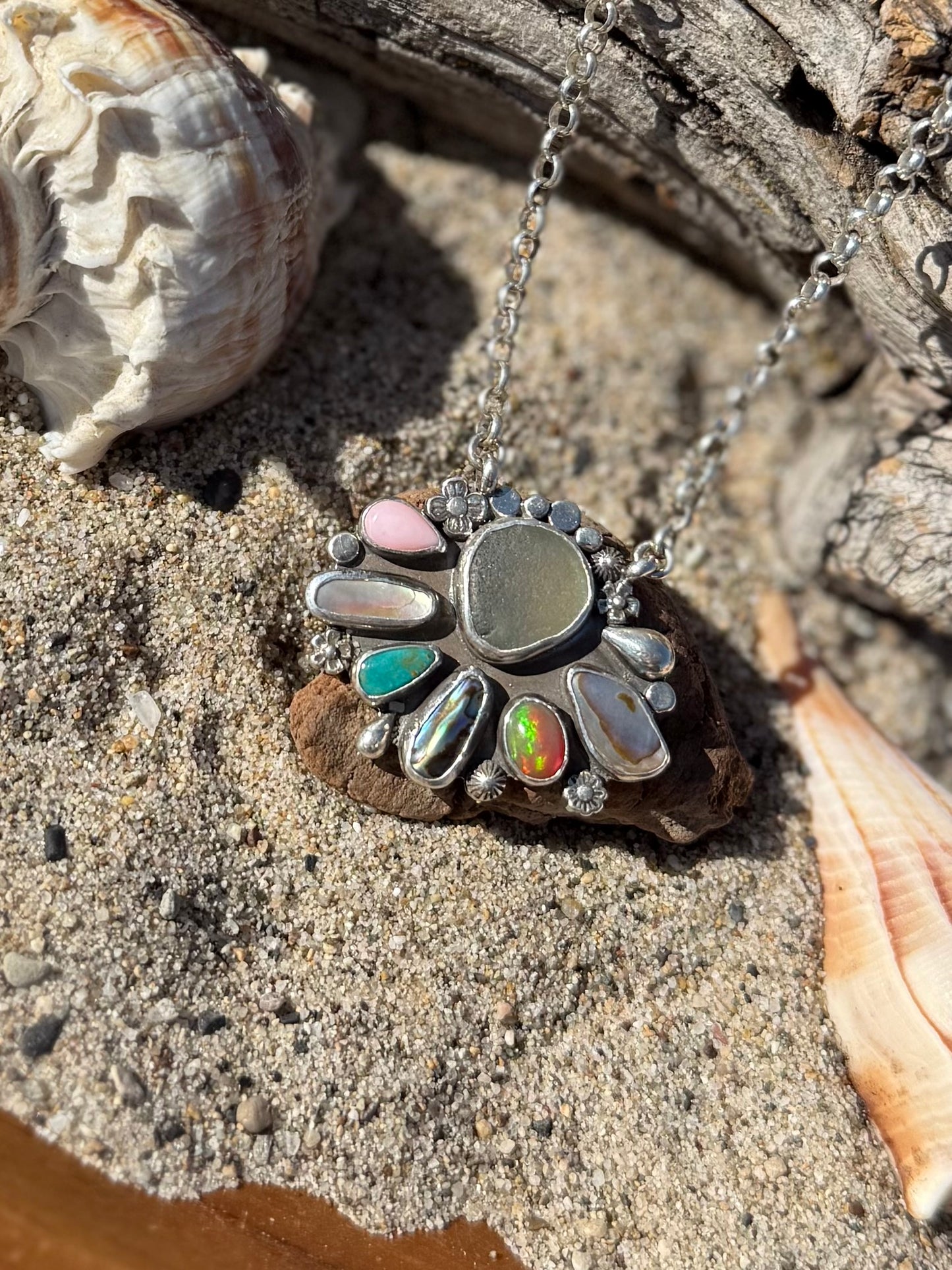 Multi stone Necklace with sea glass on a sandy surface with shells