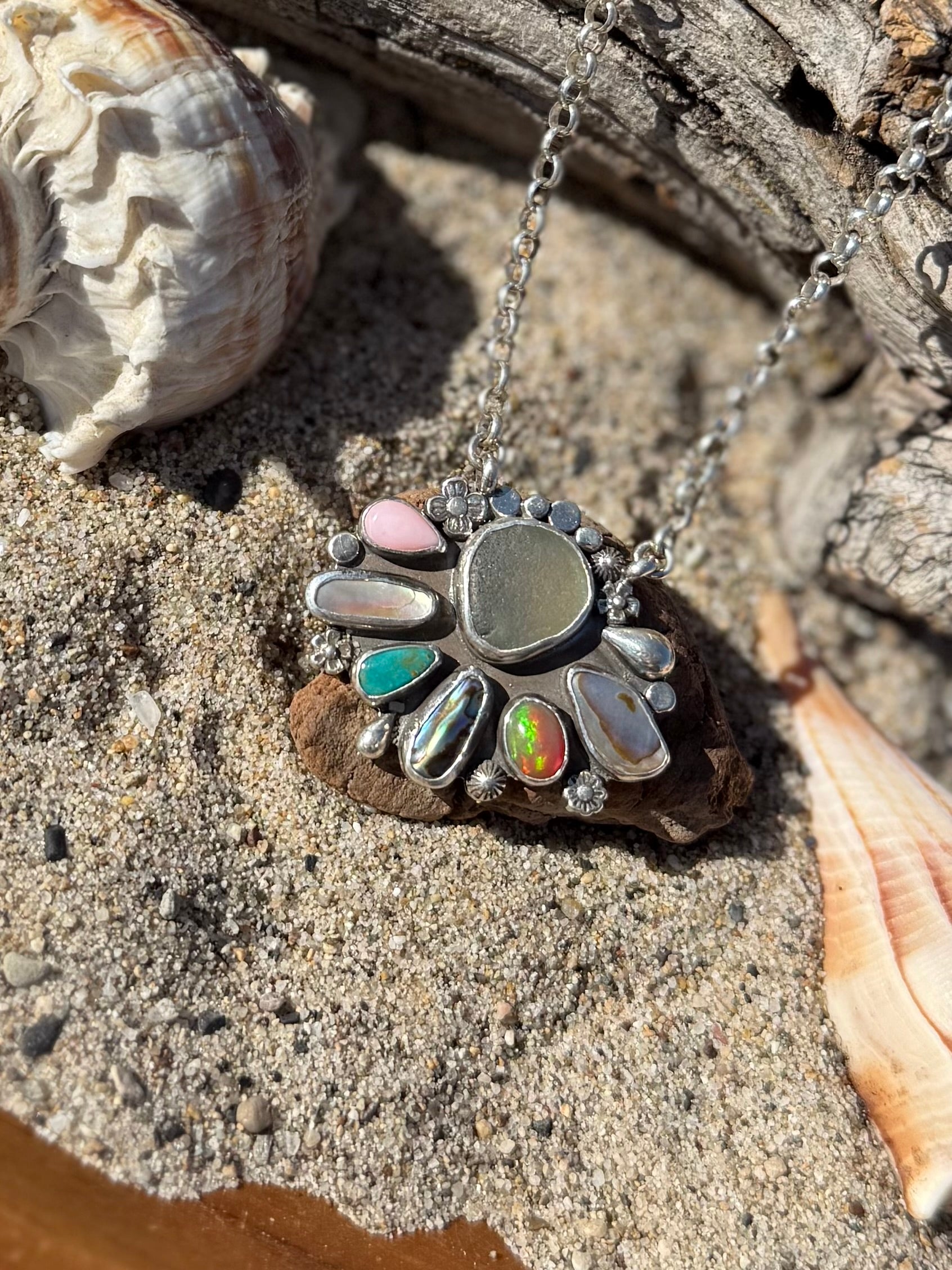Multi stone Necklace with sea glass on a sandy surface with shells