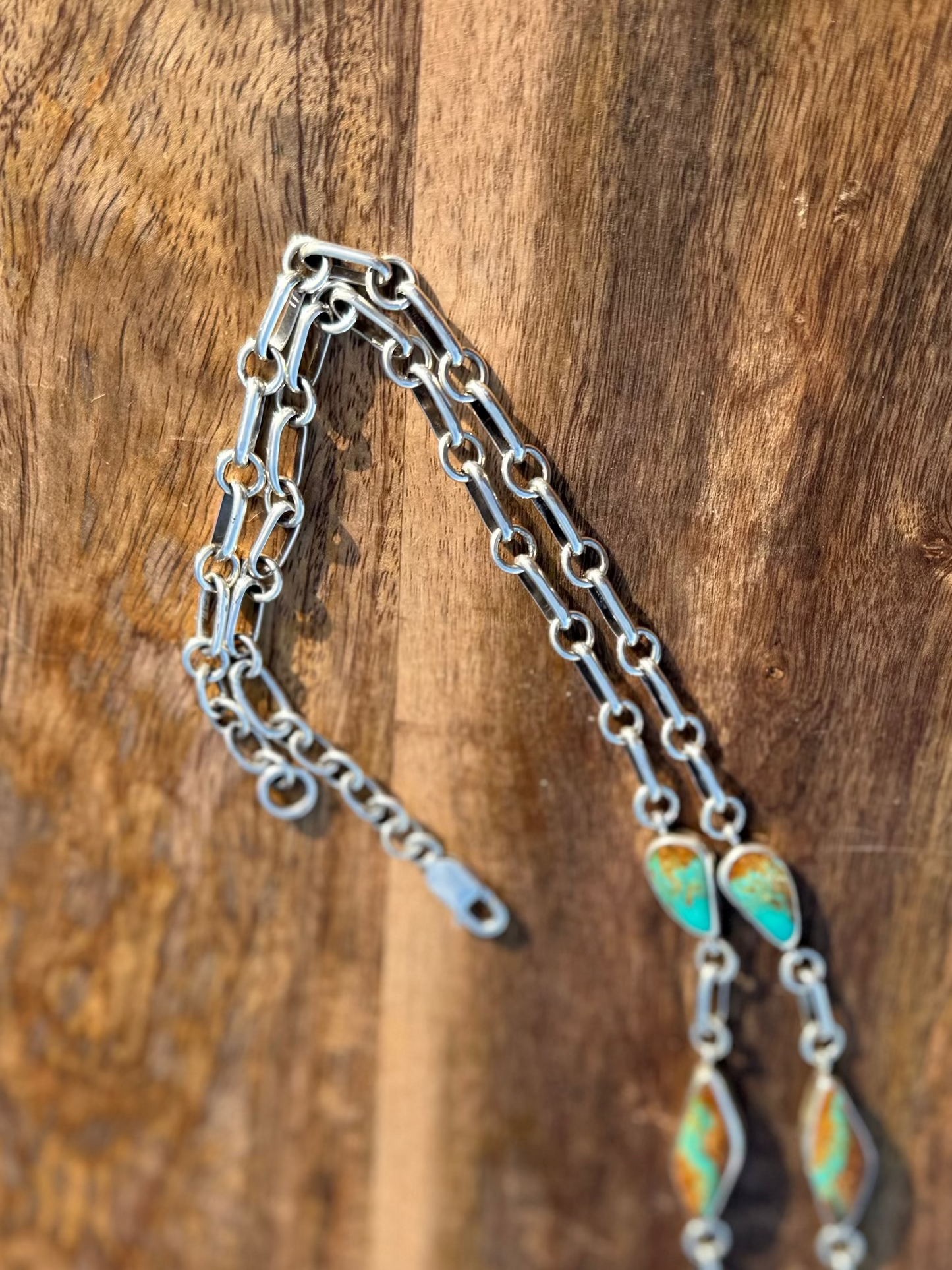 Handmade Silver chain with decorative elements on a wooden surface