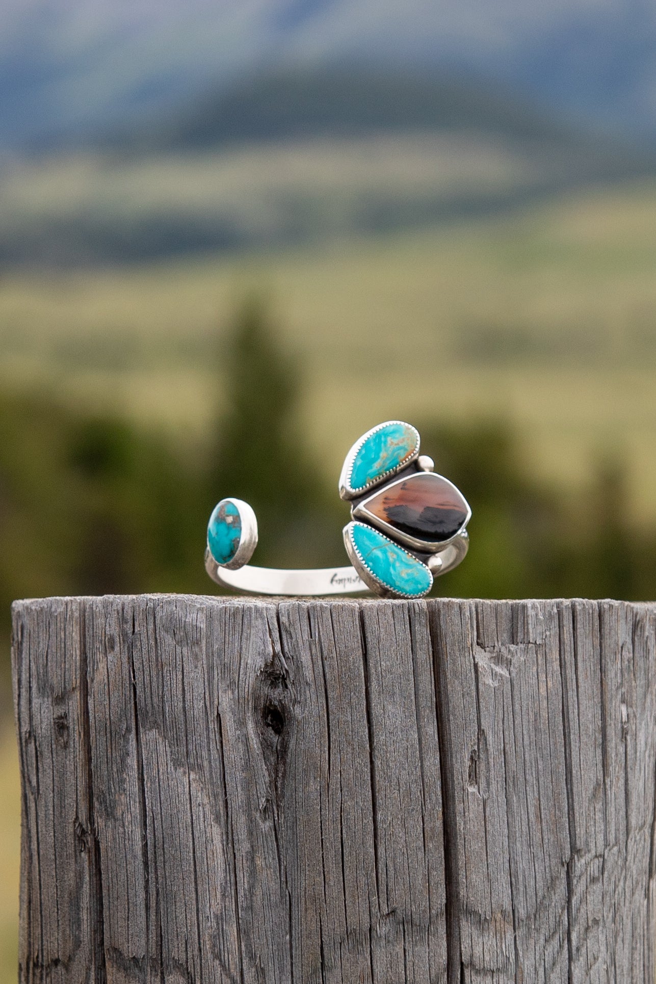 Handmade sterling silver Pinch Petal bracelet featuring scenic Montana Agate and Royston Turquoise in an adjustable western cuff design.