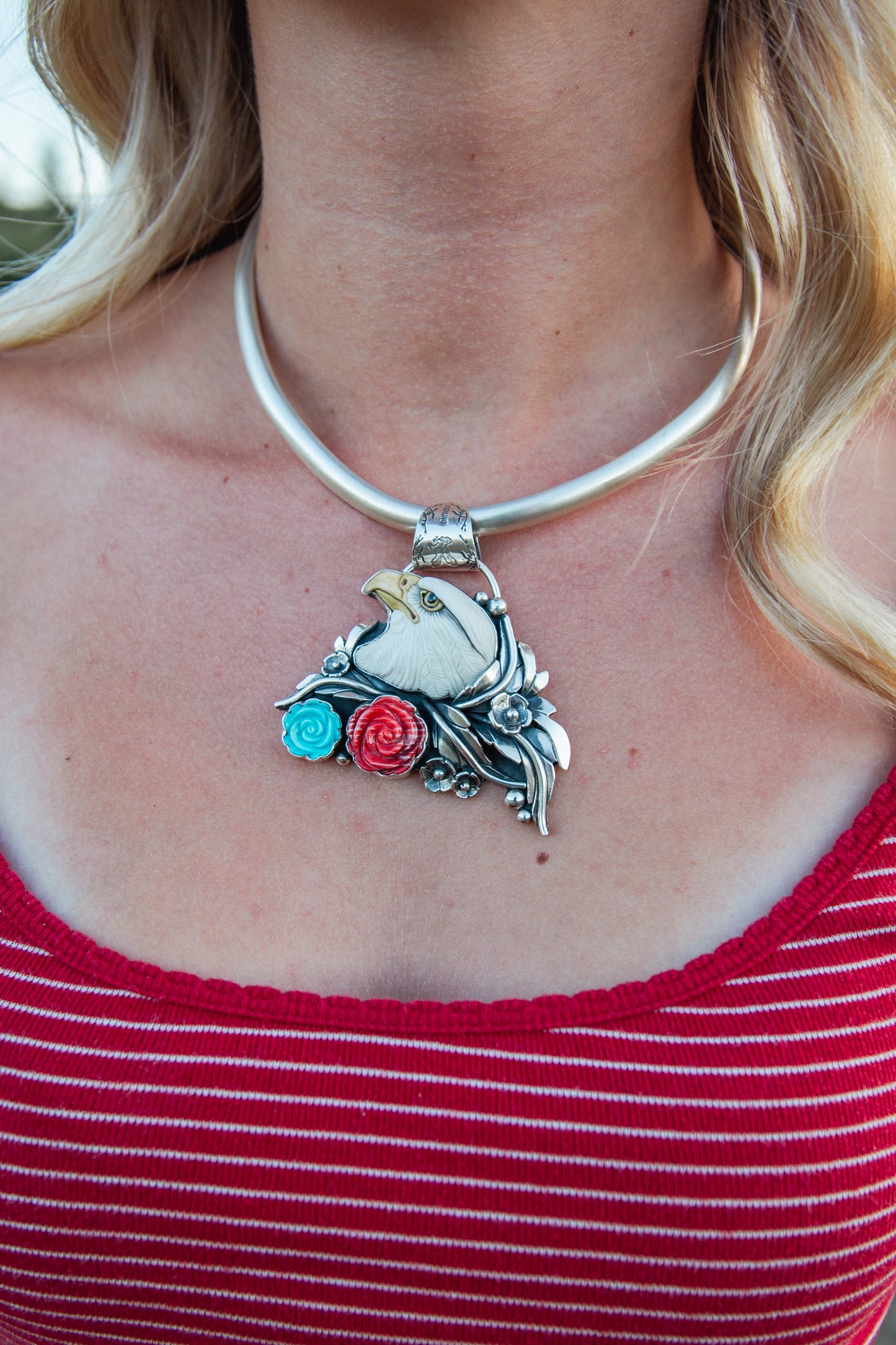 Handmade sterling silver American Eagle pendant featuring a signed Laura Mears porcelain eagle with Kingman Turquoise and Red Spiny Oyster roses.