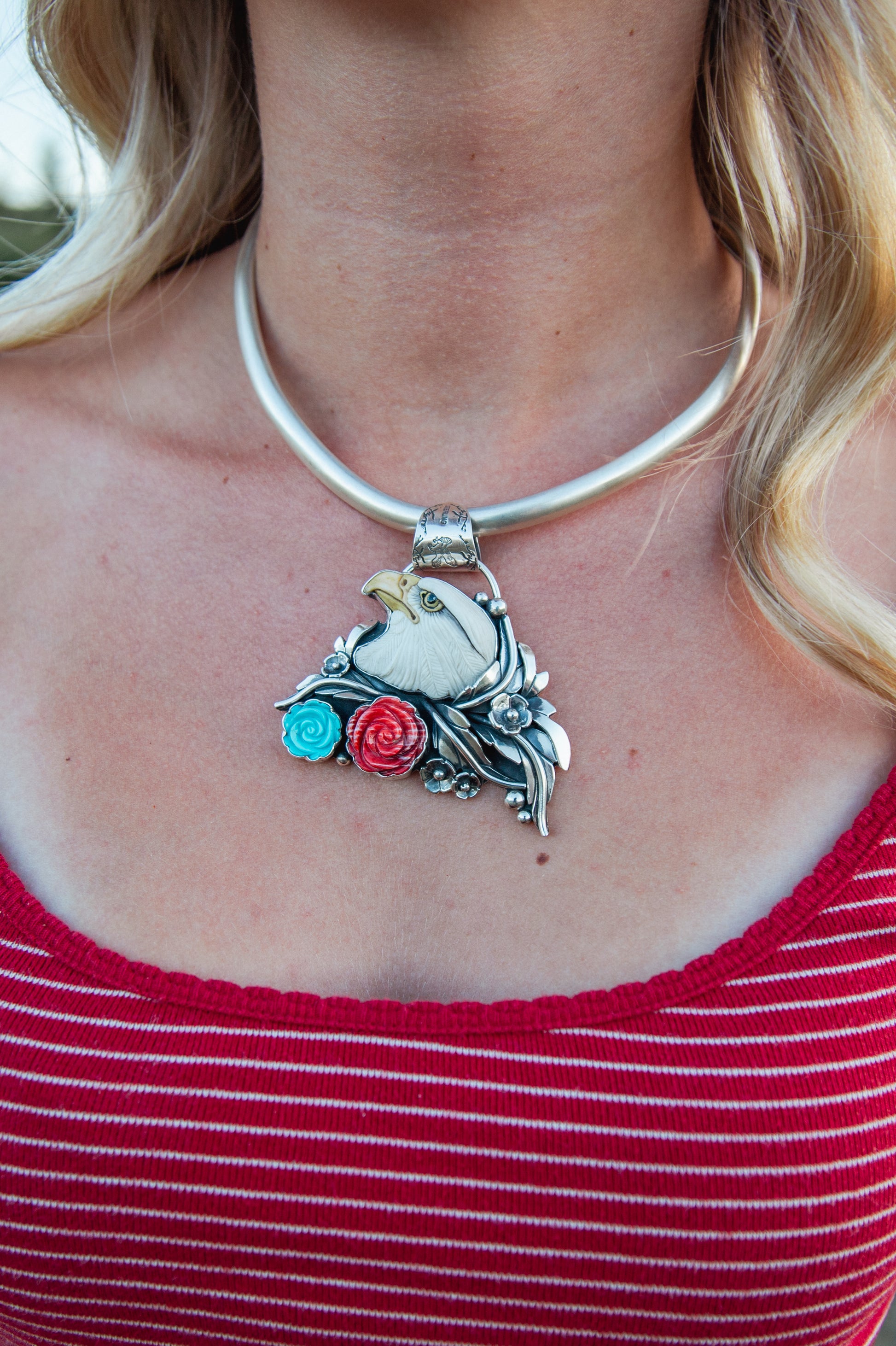 Handmade sterling silver American Eagle pendant featuring a signed Laura Mears porcelain eagle with Kingman Turquoise and Red Spiny Oyster roses.