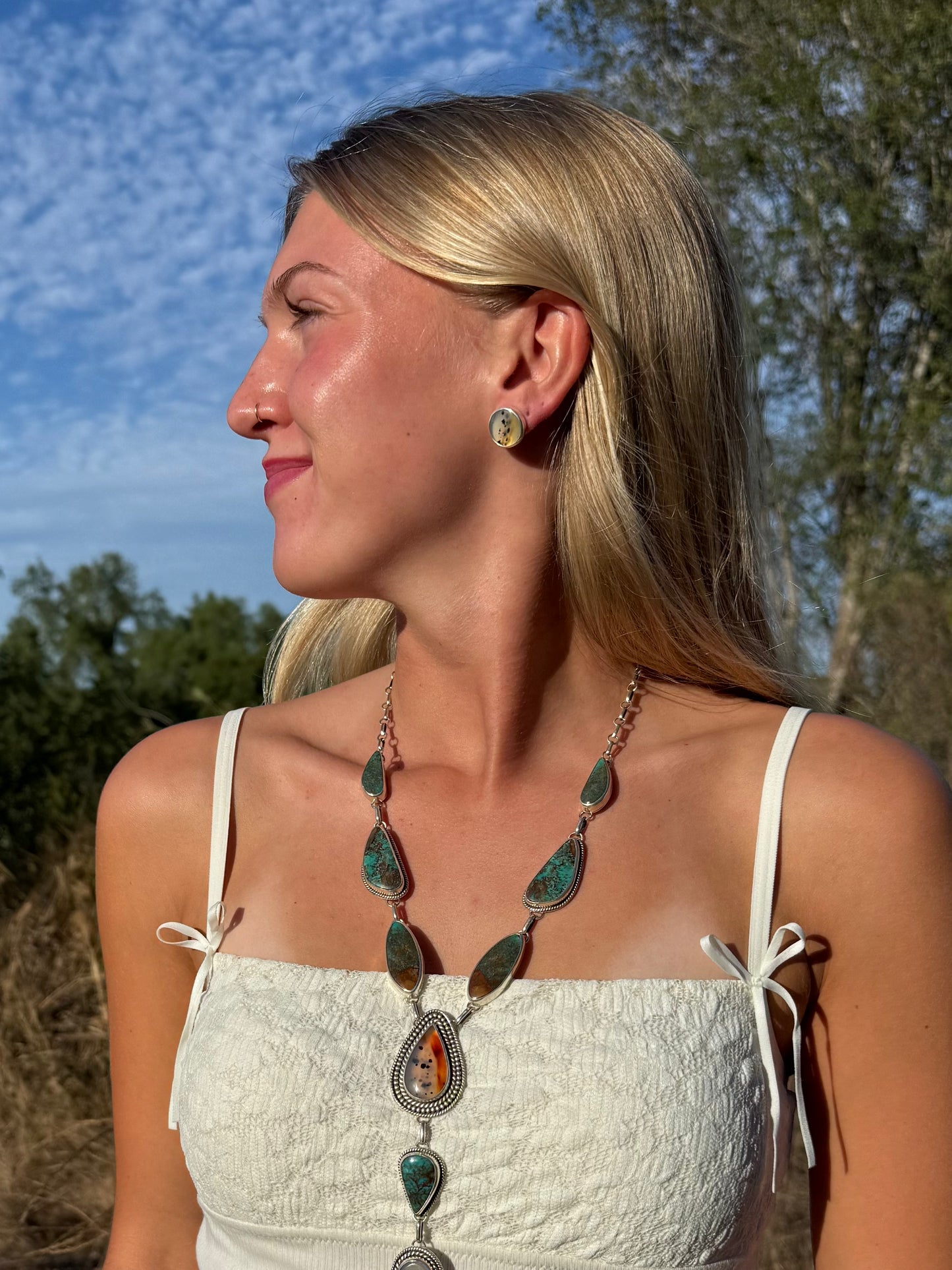Model wearing round Montana Agate stud earrings handmade in sterling silver by Donnalee Silver as part of the Montana Collection.