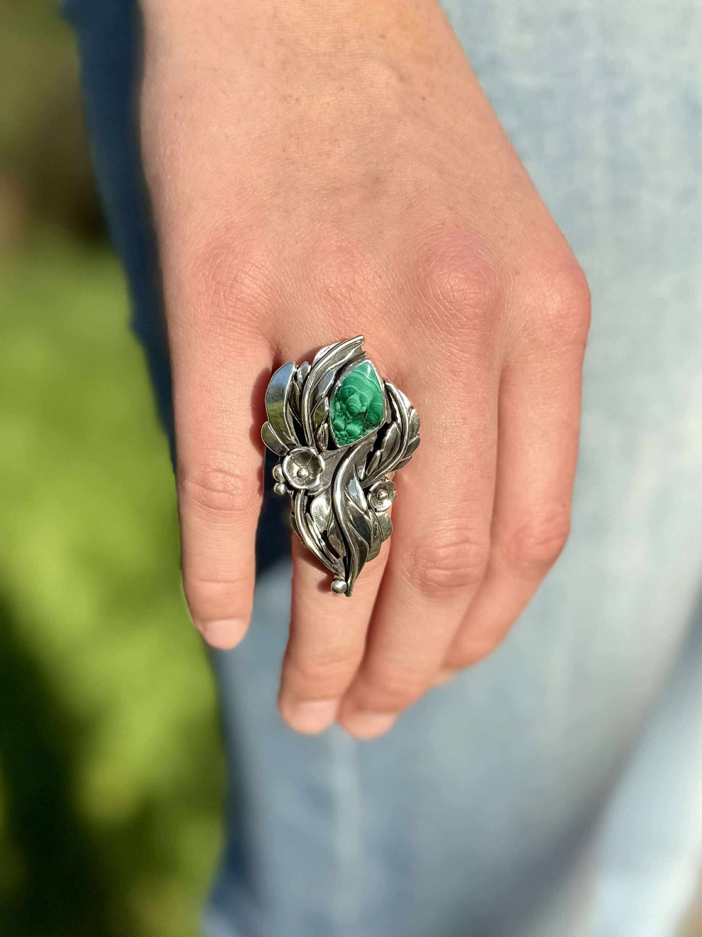 close up Malachite blossom ring showing size and proportions on finger