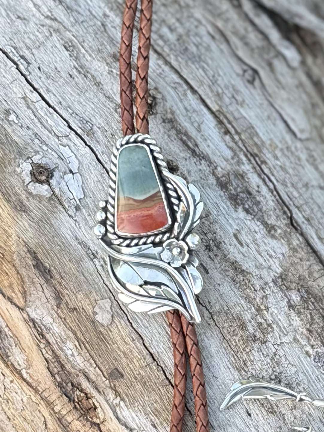 Close-up of polychrome jasper showing natural red, tan, and cream patterns with floral detail