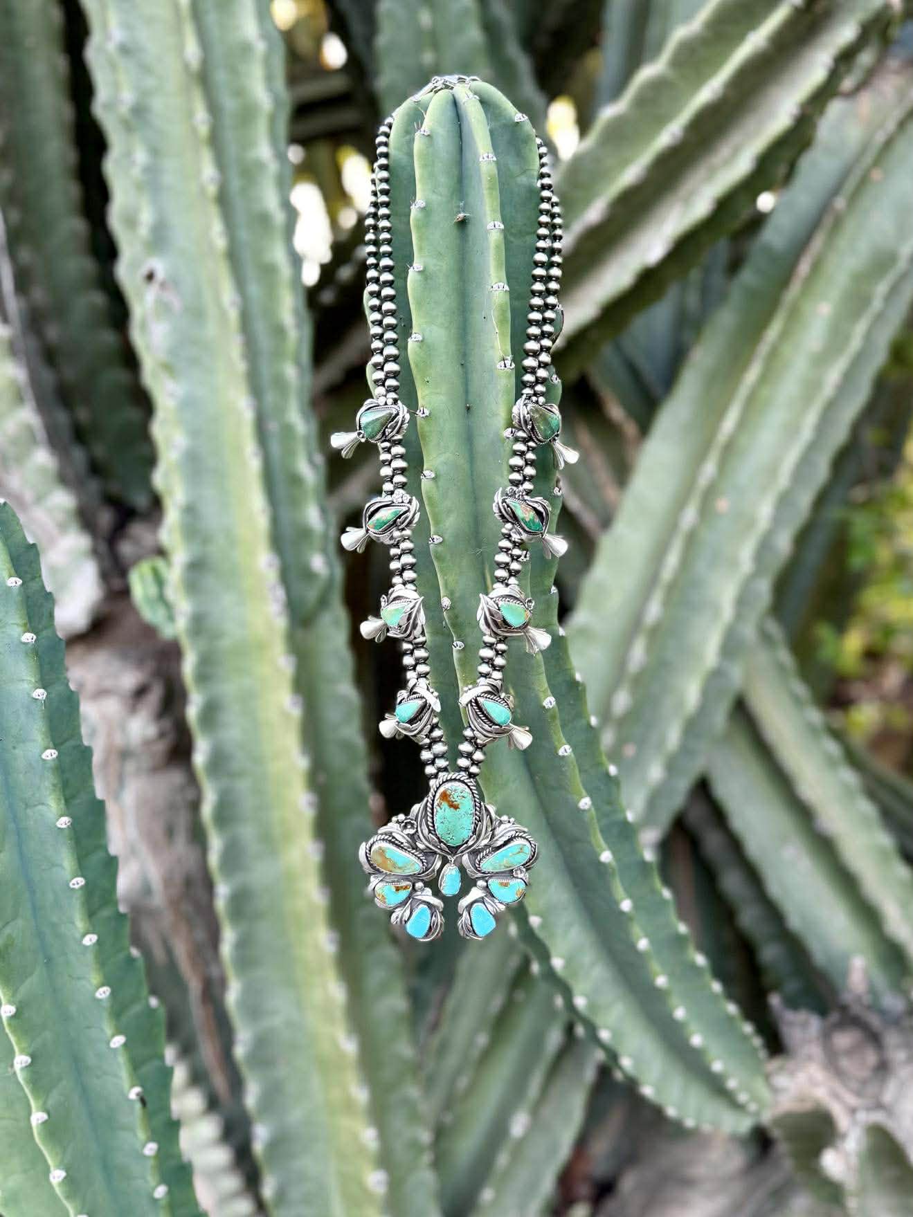 Royston turquoise ombre squash blossom necklace in sterling silver with blue to green gradient stones on a cactus